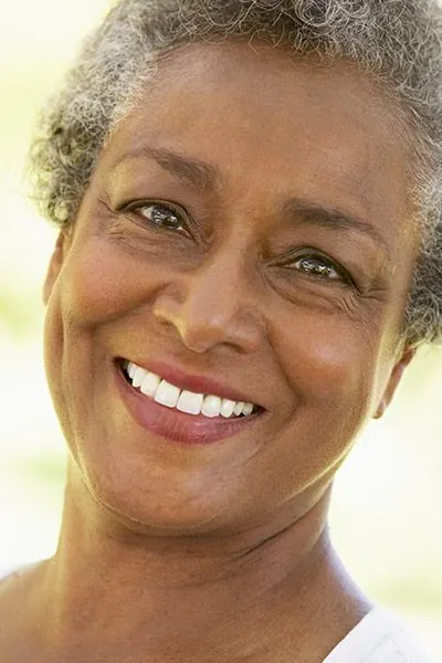 woman smiling with her new dental crowns from Smiles on Elston