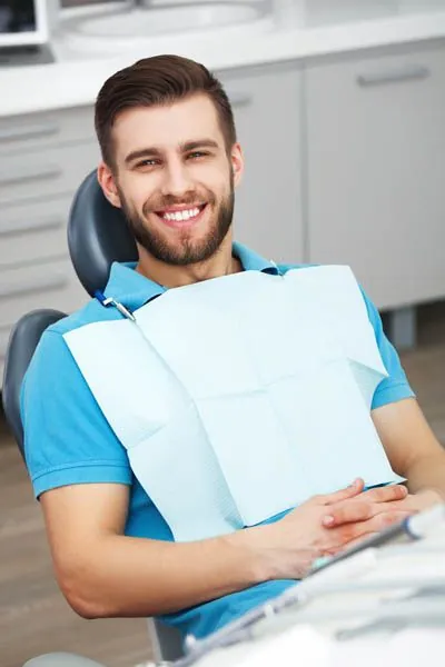 man smiling in the dental chair during his appointment at Smiles on Elston