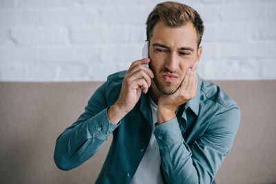 man holding his mouth from tooth pain