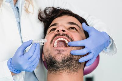 man being fitted for his Invisalign clear aligners