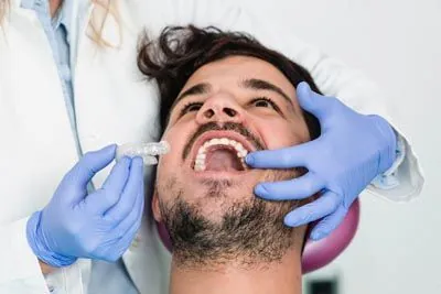 man being fitted for his Invisalign clear aligners
